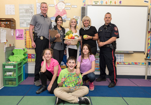 Classroom picture with a Calgary Police Officers, students, volunteers, and teachers.